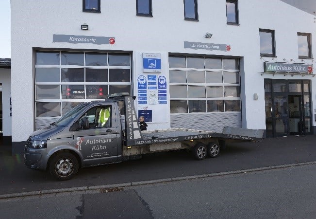 Das Abschleppauto steht vor der Werkstatt.